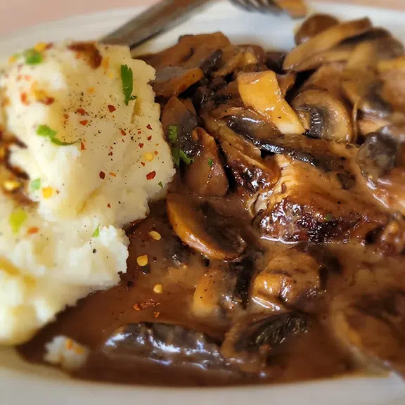 Mashed potatoes with mushroom gravy and sautéed mushrooms